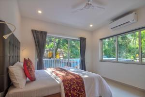 a bedroom with a bed and a large window at Amazing 2BHK Apartment Near Baga Beach By Stay Over Home in Baga