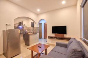 a living room with a couch and a tv and a kitchen at Amazing 2BHK Apartment Near Baga Beach By Stay Over Home in Baga
