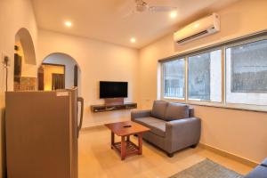 a living room with a chair and a television at Amazing 2BHK Apartment Near Baga Beach By Stay Over Home in Baga