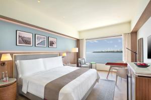 a hotel room with a bed and a large window at Trident Nariman Point in Mumbai