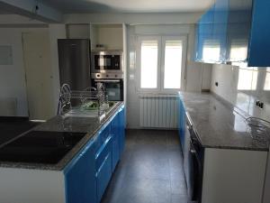 a kitchen with blue cabinets and a counter top at Casa San Miguel 93 santander in Santander