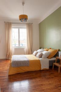 a bedroom with a large bed and a window at Appartement spacieux avec balcon et parking in Brest