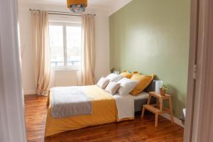 a bedroom with a bed with yellow sheets and a window at Appartement spacieux avec balcon et parking in Brest