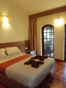 a hotel room with a bed with towels on it at Sea Breeze Village, Baga Goa in Calangute