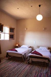 a bedroom with two beds in a room at Aghurmi Siwa Ecolodge & Salt Cave in Siwa