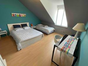 ein Schlafzimmer mit 2 Betten und einem Tisch mit einer Lampe in der Unterkunft Villa contemporaine à 2 kms de Chartres 