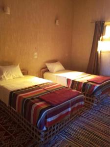 two beds in a hotel room at Aghurmi Siwa Ecolodge & Salt Cave in Siwa