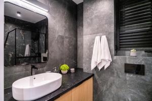 a bathroom with a white sink and a mirror at Słoneczne Polany by Apart Concept Podhale in Kościelisko +66 photos