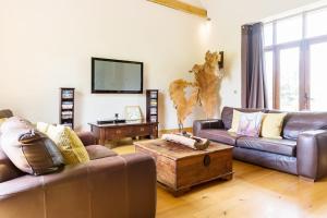 sala de estar con 2 sofás y TV en Hilltop View with Hot Tub, en Brecon