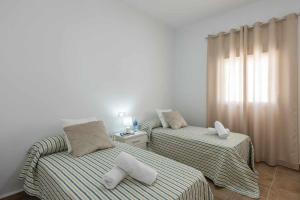 two beds with towels on them in a room at Casa Rural María Lantejuela in La Lantejuela +42 photos