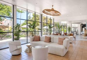 a living room with a couch and chairs and windows at Wyndham Palmas Beach and Golf Boutique Resort in Humacao