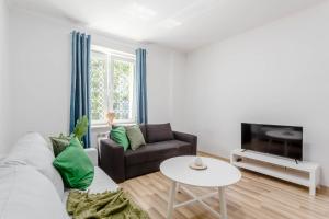 a living room with a couch and a tv at Chill Apartments Praga Waszyngtona in Warsaw