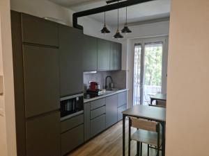 a kitchen with gray cabinets and a table and a dining room at Da Nord a Sud - Affittacamere in Milan
