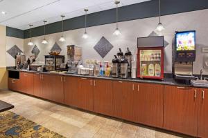 a restaurant with a counter with a refrigerator and a tv at La Quinta by Wyndham Stonington-Mystic Area in Pawcatuck