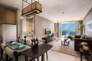 a living room with a table and a dining room at Wyndham Sanya Bay in Sanya