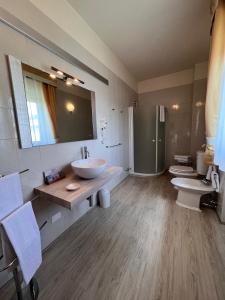 un ampio bagno con due lavandini e due servizi igienici di Hotel Conca d'Oro a Salò