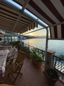 einen Balkon mit Stühlen, einem Tisch und Wasser in der Unterkunft Notti sul mare a Villa Chiara in Marina di Casalvelino