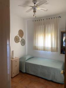 a bedroom with a bed and a ceiling fan at Playa Antilla Golf in Lepe +15 photos