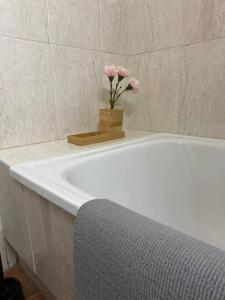 a white bath tub with a vase of pink flowers at Playa Antilla Golf in Lepe +15 photos