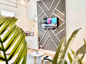 a living room with a tv on a wall at Central City Townhouse Leicester - 3 Bedroom House in Leicester