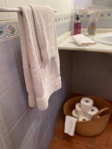 a bathroom with white towels and a basket of toilet paper at Playa Antilla Golf in Lepe