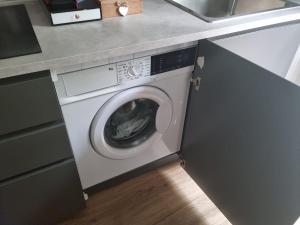 a washing machine in a kitchen next to a sink at Da Nord a Sud - Affittacamere in Milan