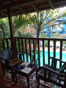 a table and chairs on a porch with a palm tree at Sea Breeze Village, Baga Goa in Calangute