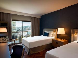 a hotel room with two beds and a window at Fairmont Rio de Janeiro Copacabana in Rio de Janeiro