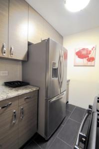 La cuisine est équipée d'un réfrigérateur en acier inoxydable. dans l'établissement 2 BR 1.5t Bath in Midtown West, à New York