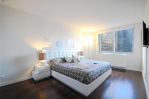 biała sypialnia z łóżkiem i oknem w obiekcie 2 BR 1.5t Bath in Midtown West w Nowym Jorku