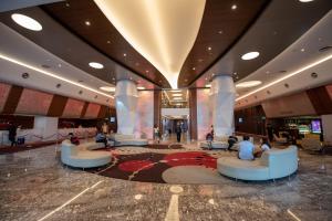 a lobby with people sitting on couches in a building at Sunway Resort Suites @Cozy Studio with Lagoon View in Petaling Jaya