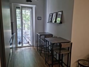 een kamer met 3 barkrukken, een tafel en een raam bij Da Nord a Sud - Affittacamere in Milaan