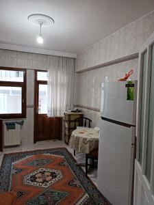a kitchen with a white refrigerator and a table at hamdihome in Akcaabat