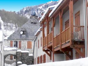 a building with wooden balconies in the snow at Appartement Vignec, 2 pièces, 6 personnes - FR-1-504-101 in Vignec