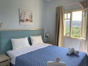 a bedroom with a blue bed and a window at Dialinas Apartments in Istro +181 photos