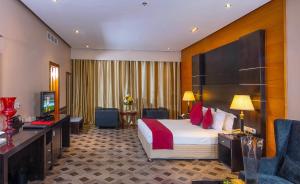 a hotel room with a bed and a television at Diva Hotel in Manama
