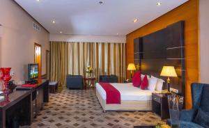una habitación de hotel con una cama y un televisor en Diva Hotel, en Manama