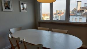 a white table and chairs in a room with a window at Memoria 49 in Lisbon