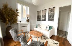 a living room with a table and chairs and a couch at La Côte in Granville