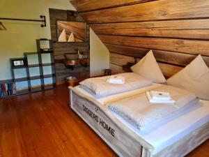 ein Bett in einem Zimmer mit einer Holzwand in der Unterkunft Western Cottage Hocheifel in Wirft