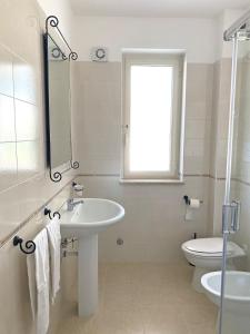 bagno con lavandino, servizi igienici e finestra di Villetta Paestum a Mattine