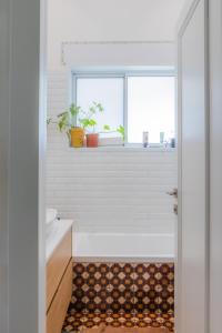 a bathroom with a tub and a sink and a window at Tel Aviv Center Seaside Villa with a Pool & Rooftop in Tel Aviv