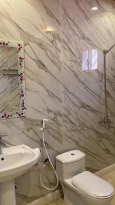 Łazienka z białą toaletą i umywalką w obiekcie الجوهرة Diamond plus w mieście Al-Ula