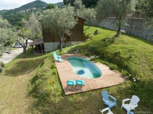 - une vue sur la piscine avec des chaises et une terrasse dans l'établissement Oliveraie d'Olmiccia, à Olmiccia
