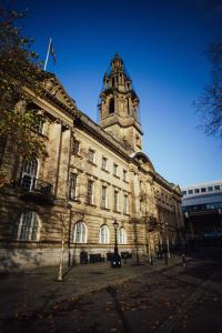 um grande edifício com uma torre de relógio em cima em 7 Cannon Street em Preston