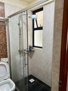 La salle de bains est pourvue d'une douche et de toilettes. dans l'établissement Forest's Simplistic Home with a dedicated study, à Nairobi