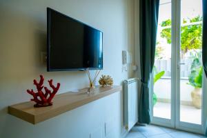 einen Flachbild-TV an einer Wand neben einem Fenster in der Unterkunft Casa Corallium in Torre del Greco