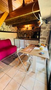 a living room with a table and a red couch at Studio au calme avec piscine partagée in Saint-Martin-la-Méanne