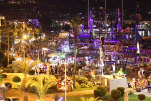 a city lit up at night with people at Beautiful Sultan House at Cleopatra beach 1 with umbrellas, balcony, barbecue, private 100mbps WiFi, smart TV, table games, WhatsApp Support in Alanya