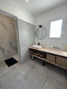 La salle de bains est pourvue d'un lavabo et d'un miroir. dans l'établissement Belle villa neuve avec jardin et parking, à Calenzana